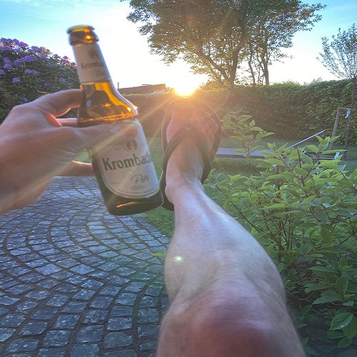 Mann trinkt Erfrischungsgetränk im Sonnenuntergang